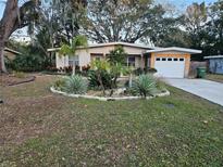 Ranch style home with landscaped yard and attached garage at 206 Cooke St, Leesburg, FL 34748