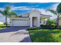 One-story house with a two-car garage and a landscaped yard at 8990 Ace Loop, Davenport, FL 33896