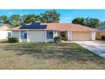 One-story house with solar panels and a landscaped yard at 117 Red Rose Cir, Orlando, FL 32835
