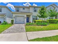 Two-story house with gray siding, blue door, and a paved driveway at 1636 Moon Valley Dr, Davenport, FL 33896