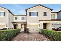 Two-story townhome with brick paver driveway and landscaping at 2766 White Isle Ln, Orlando, FL 32825