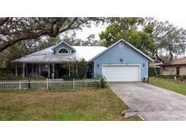 Charming blue house with white picket fence and large yard at 1215 Timberidge Dr, Lakeland, FL 33809