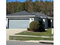 House exterior featuring a two-car garage and well-maintained lawn at 4633 Glencrest Loop, St Cloud, FL 34772
