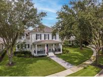 Two-story house with front porch, landscaped lawn, and walkway at 5910 Caymus Loop, Windermere, FL 34786