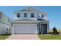 Two-story house with gray siding, white trim, and a two-car garage at 6805 Serpent Hawk Lane St, Howey In The Hills, FL 34737