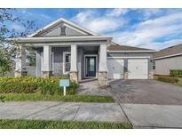Beautiful two-story home with gray exterior, white columns, and a two-car garage at 15155 Mayberry Dr, Winter Garden, FL 34787