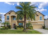Two-story house with tan exterior, palm trees, and a three-car garage at 1827 Pisgah Ln, Apopka, FL 32712