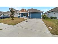 Newly built home with blue exterior, two-car garage, and small front yard at 225 Arbuthnot St, Winter Haven, FL 33881