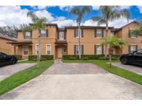 Tan two-story townhome with palm trees and brick driveway at 3030 Calabria Ave # 436, Davenport, FL 33897