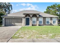Single-story house with a two-car garage and well-maintained lawn at 3621 Ronda Dr, Deltona, FL 32738