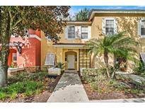 Inviting two-story townhome with attractive landscaping and a welcoming front entrance at 8443 Crystal Cove Loop, Kissimmee, FL 34747
