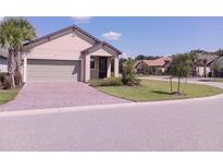 Single-story home with a two-car garage and landscaped front yard at 573 Lago Matisse St, Kissimmee, FL 34759