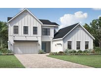 Two-story farmhouse with white siding, black windows, and a three-car garage at 9604 English Laurel, Orlando, FL 32827