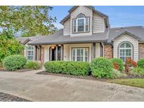 Two story house with gray siding, brown roof, and manicured landscaping at 333 N Spaulding Cv, Lake Mary, FL 32746