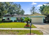 Light blue house with a beige garage and well-maintained lawn at 3007 Fayson Cir, Deltona, FL 32738
