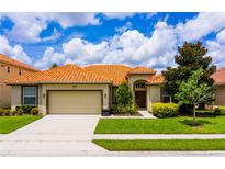One-story home with tile roof, two-car garage, and landscaped lawn at 4027 Oakrise Loop, Davenport, FL 33837