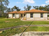 Single-story home with brown roof and well-maintained lawn at 5933 Bible Camp Rd, Groveland, FL 34736