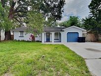 Charming single-story home with a landscaped lawn and blue garage door at 1440 Dann St, Orlando, FL 32804