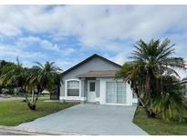 Single-story home with gray exterior, driveway, and palm trees at 2633 Daffadil Ter, Sanford, FL 32771