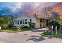 Mobile home exterior features a landscaped yard and a driveway at 6399 Lolly Bay Ne Loop, Winter Haven, FL 33881