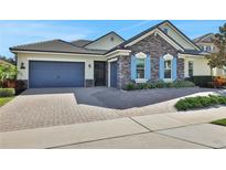Beautiful stone and shingle exterior, two-car garage, and paved driveway at 3875 Grassland Loop, Lake Mary, FL 32746