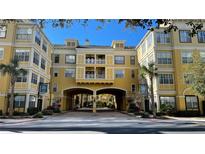 Luxury condo building with arched entryway and lush landscaping at 860 N Orange Ave # 118, Orlando, FL 32801