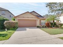 Single-story house with brown garage door and landscaped lawn at 12755 Oulton Cir, Orlando, FL 32832