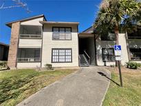 Exterior view of a two-story condo building with stairs and landscaping at 4615 Cason Cove Dr # 823, Orlando, FL 32811