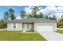 Newly constructed one-story home with gray roof and white garage door at 15460 Sw 47Th Avenue Rd, Ocala, FL 34473