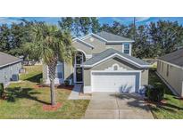 Two-story house with gray siding, white garage door, and palm tree in front at 8048 King Palm Cir, Kissimmee, FL 34747