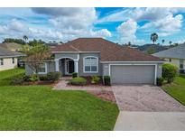 One-story home with brown roof, gray exterior, and a brick paved driveway at 344 Barbera Dr, Davenport, FL 33897