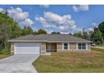 One-story home with attached garage and driveway at 12472 Sw 85Th Pl, Dunnellon, FL 34432