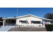 Cute yellow house with red accents and carport at 9035 Sw 102Nd Pl, Ocala, FL 34481