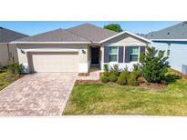 One-story house with beige siding, brown shutters, and paved driveway at 4336 Nw 55Th Ct, Ocala, FL 34482