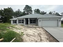 One-story home with gray siding, black shutters, and two-car garage at 11600 Sw 55Th Ave, Ocala, FL 34476