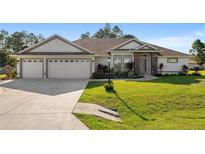 Beautiful house with three car garage and manicured lawn at 5005 Sw 106Th St, Ocala, FL 34476
