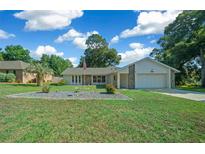 One-story home with stone accents and a neat lawn at 13027 Ne 7Th Loop, Silver Springs, FL 34488