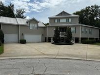 Two-story house with a three-car garage and a landscaped yard at 56633 Otter Rd, Astor, FL 32102