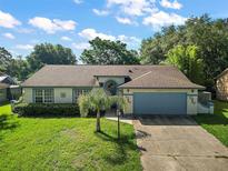 One-story home with a blue garage door and well-manicured lawn at 303 Oak Lane Dr, Ocala, FL 34472