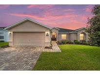 One-story house with a beige exterior and brick driveway at 16292 Sw 13Th Ter, Ocala, FL 34473