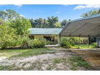 Single-story home with carport and landscaping at 7679 S Magnolia Ave, Ocala, FL 34476