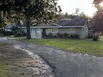 Single story home with a large grassy yard and long driveway at 3250 Se Lake Weir Ave, Ocala, FL 34471