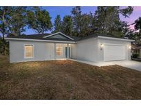 Two-bedroom home with a two-car garage and landscaping at 5 Emerald Trl, Ocala, FL 34472