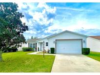 Single-story home with white siding and a two-car garage at 892 Nash Loop, The Villages, FL 32162