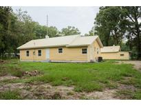 Yellow house with metal roof and detached garage at 1750 Ne 180Th St, Citra, FL 32113