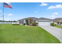 Single-story home with two-car garage and lush lawn at 3967 Se 99Th St, Belleview, FL 34420