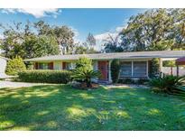 Ranch house with red door and landscaped lawn at 743 Ne 26Th Ter, Ocala, FL 34470