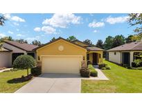 House exterior featuring a two-car garage and manicured lawn at 9472 Sw 76Th St, Ocala, FL 34481