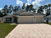 Two-story house with a three car garage and landscaped yard at 7088 Sw 179Th Court Rd, Dunnellon, FL 34432