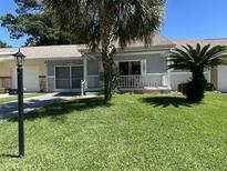 Charming house exterior with a covered porch and lush landscaping at 8671 Sw 97Th St, Ocala, FL 34481